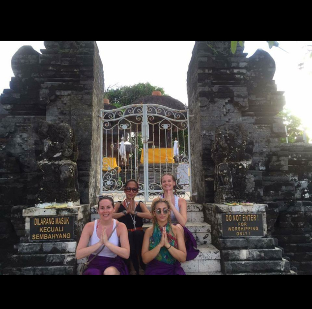 4 women praying outside a temple in Bali 